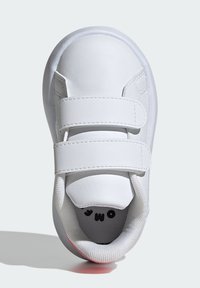 White sneaker with two hook-and-loop straps, smooth leather upper, padded collar, and textured insole. Rubber sole with subtle color accent.