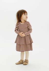 Abito a maniche lunghe a righe in bordeaux e crema con gonna a strati. Abbinato a collant crema a coste e scarpe beige con pois dorati.