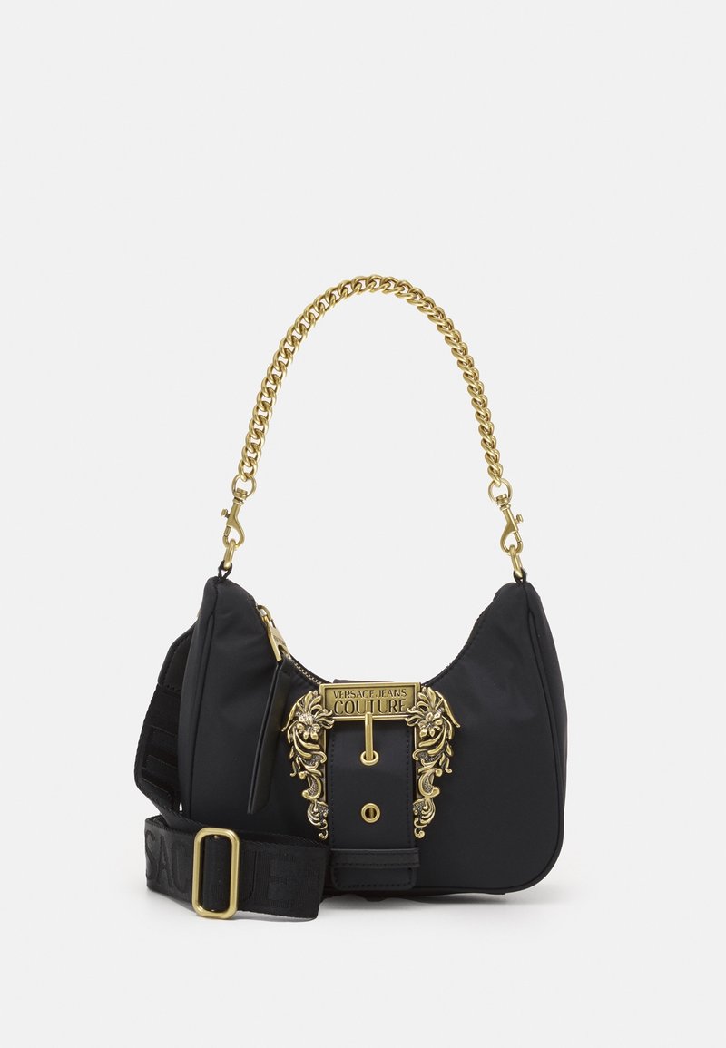 Black nylon handbag with a gold chain handle and ornate hardware. Features a prominent logo and a fabric strap with branding.
