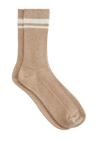 Gebreide beige sokken met ribbeltextuur en twee witte strepen aan de bovenkant. Zacht materiaal, halverwege de kuit en gestructureerde vorm.