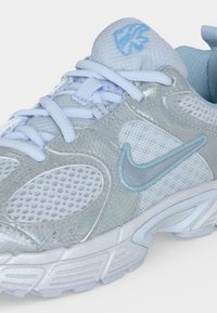 Ανοιχτό μπλε και λευκό παπούτσι για τρέξιμο Nike με πλέγμα και υφασμάτινα πάνελ, επενδυμένη γλώσσα, κορδόνια και κεντημένο λογότυπο Swoosh στο πλάι.