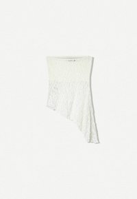 Vit spetsvattfallstop med asymmetrisk fåll, med texturerad tyg och en åtsittande byst som övergår till en löst, flödande botten.