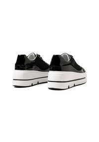 Sneakers neri con accenti in pelle verniciata lucida, tessuto testurizzato e una suola bianca spessa con una striscia nera. Chiusura con lacci standard.