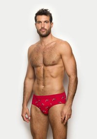 Czerwone majtki z miękkiego materiału, z powtarzającym się wzorem małych, rysunkowych postaci na powierzchni, elastyczny pas i gładka tekstura.