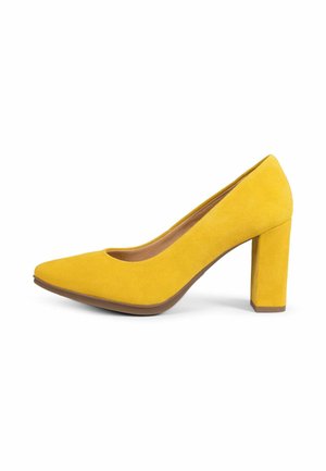 Zapato de tacón alto de ante amarillo con puntera puntiaguda y tacón ancho sobre fondo blanco.