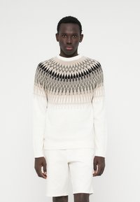 Strickpullover mit geometrischem Muster in Beige, Grau und Schwarz, auf cremefarbenem Grund. Rippkragen und -bündchen, normaler Schnitt.