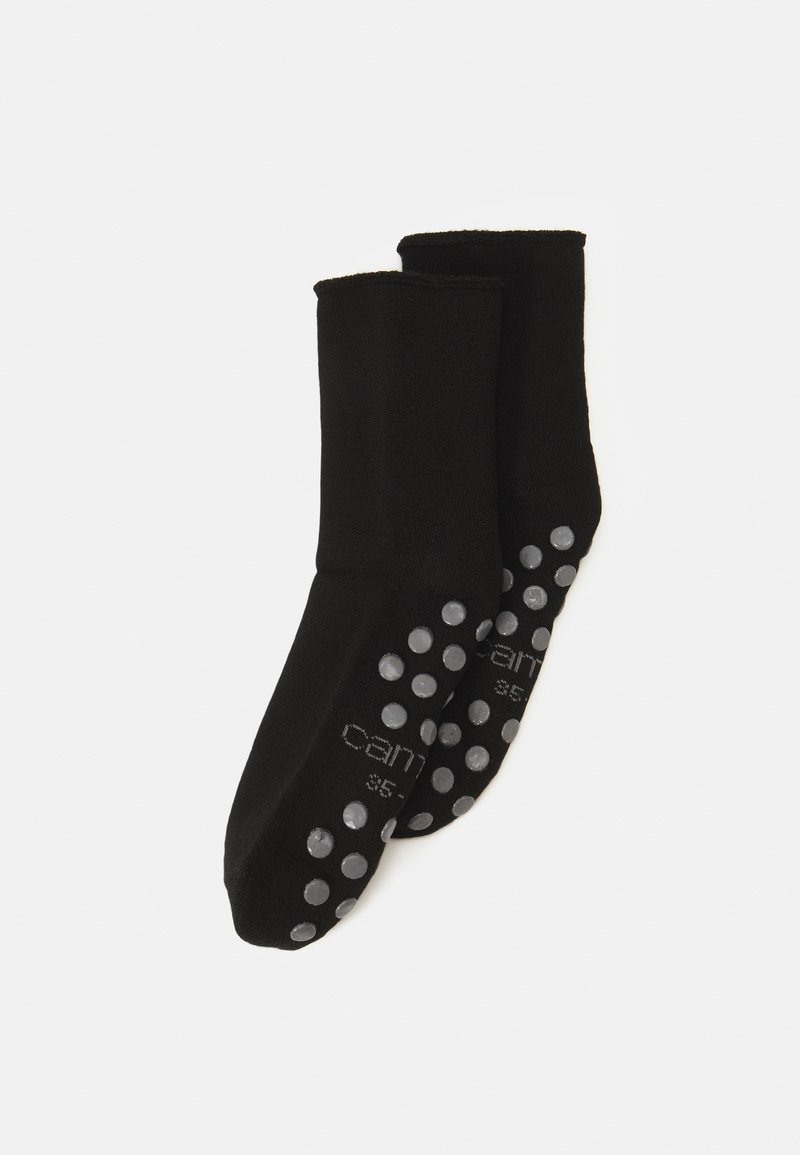 Chaussettes noires en matière douce avec une texture lisse. Les semelles sont dotées de ronds en caoutchouc gris pour une adhérence et une traction accrues.