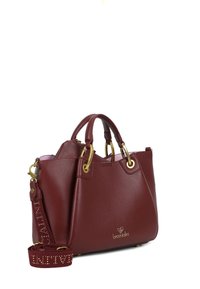Borsa in pelle borgogna con doppi manici, dettagli in hardware dorato e una tracolla removibile con lettere borchiate. Texture liscia e forma strutturata.