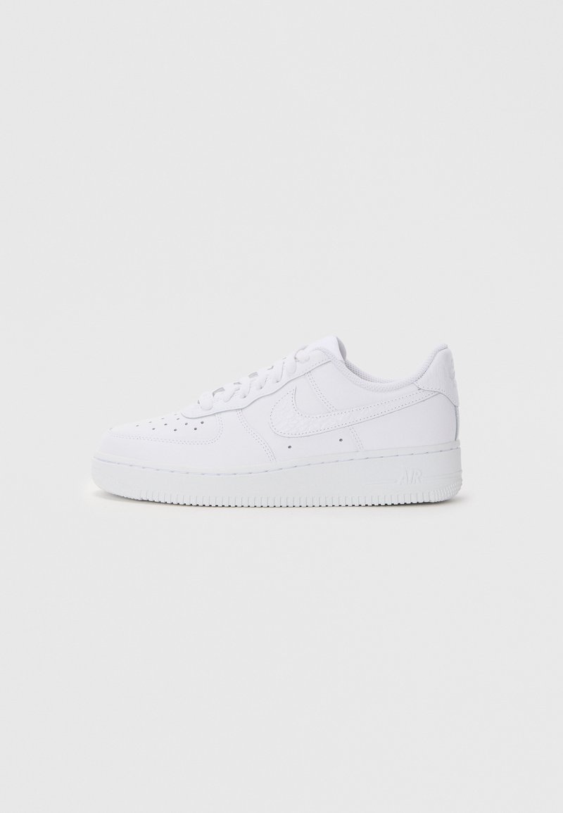 Valged Nike Air Force 1 sneekerid nahast ülemise osaga, ümmarguse varbaga, paeltega sulgemisega, pehmendatud kaelusega ja tekstureeritud kummist tallaga.