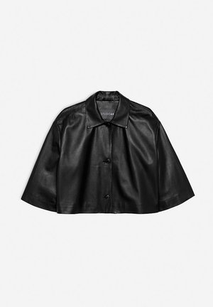 Zwarte cropped leren jack met een klassieke kraag, knoopsluiting en korte mouwen. Gladde textuur, minimale stiksels en een modern snit.