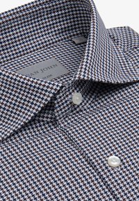 Slim-fit skjorte i marineblå, hvid og brun houndstooth mønster, med spredt krave og en enkelt knaplukning med perleoverflade.