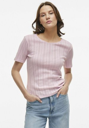 Lichtroze gebreide t-shirt met korte mouwen, met een gestructureerd patroon en een ronde halslijn, gecombineerd met lichtblauwe jeans.