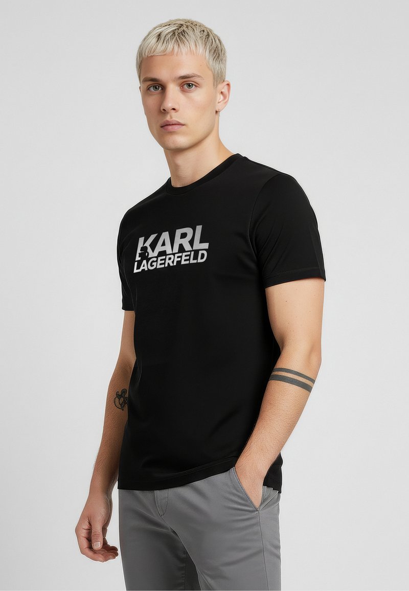 Czarny t-shirt z krótkim rękawem z białym logo „KARL LAGERFELD”. Wykonany z gładkiej tkaniny, z okrągłym dekoltem i dopasowanym krojem.