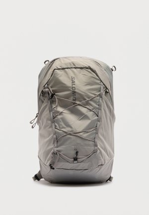 Helehall Salomoni XT 15 seljakott esikaablite, võrkküljetaskute ja ülemise lukuga sektsiooniga, seisab valgel taustal püsti.