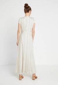 Maxi dress in light fabric, featuring vertical stripes, short sleeves, a fitted waist, and a flowing silhouette down to the ankles.