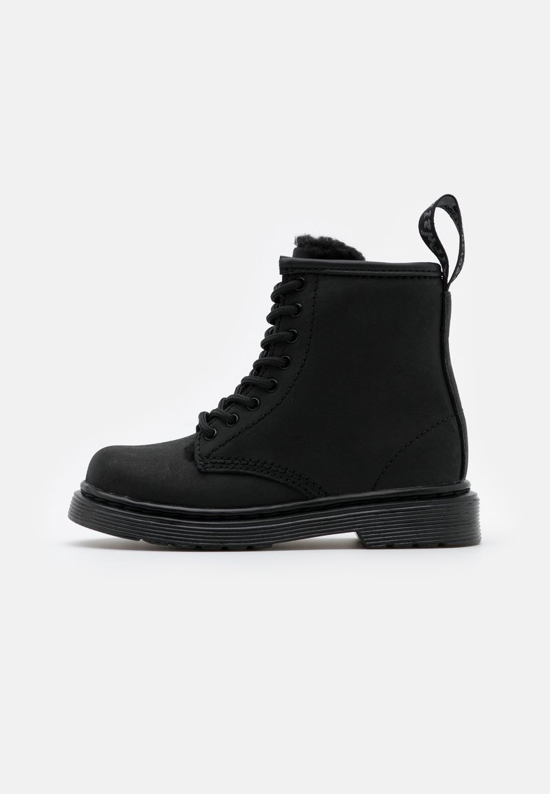 Bottine montante en cuir noir avec lacets, semelle épaisse, languette au talon et doublure intérieure douce, montrée en profil sur fond blanc.