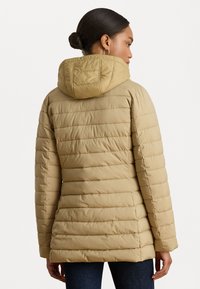 Casaco puffer castanho com costuras horizontais, capuz e mangas longas. O material parece suave e isolado para proporcionar calor.