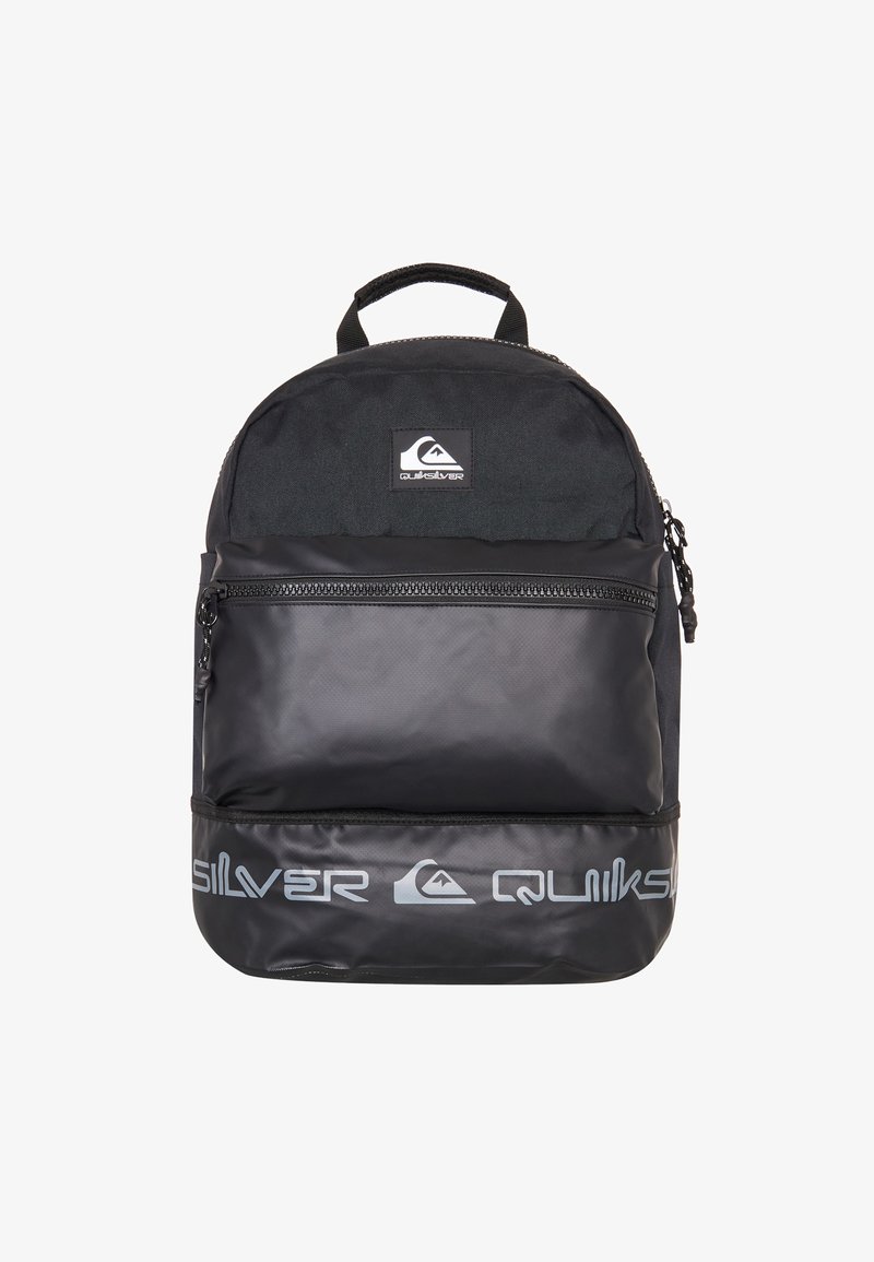 Mochila negra con una parte superior de tela texturizada y una sección inferior de material sintético suave. Presenta un bolsillo frontal con cremallera y un logo en la parte superior.