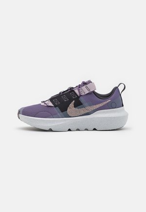Purple athletic shoe with a mesh upper, black accents, and a chunky grey sole. Features lace and strap closure, and a prominent logo on the side.