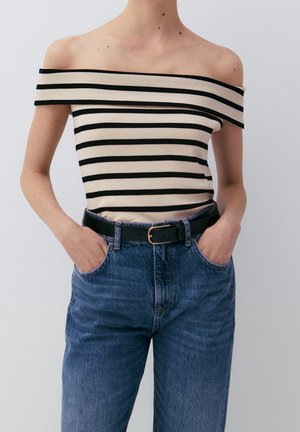 Schwarz-beiges, gestreiftes Off-Shoulder-Top mit figurbetontem Design, kombiniert mit hoch taillierten blauen Jeans und einem schwarzen Gürtel. Schlanke, legere Passform.