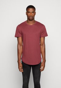 Burgunder T-Shirt mit Rundhalsausschnitt und kurzen Ärmeln, mit abgerundetem Saum. Hergestellt aus weichem Stoff, bietet eine lockere Passform.