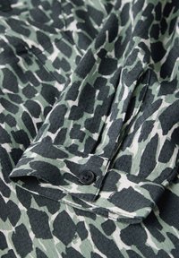 Katoenen overhemd met een groen en zwart dierenprint, met knoopsluiting en textuurstof. Gefacetteerde kraag en gestructureerd ontwerp.
