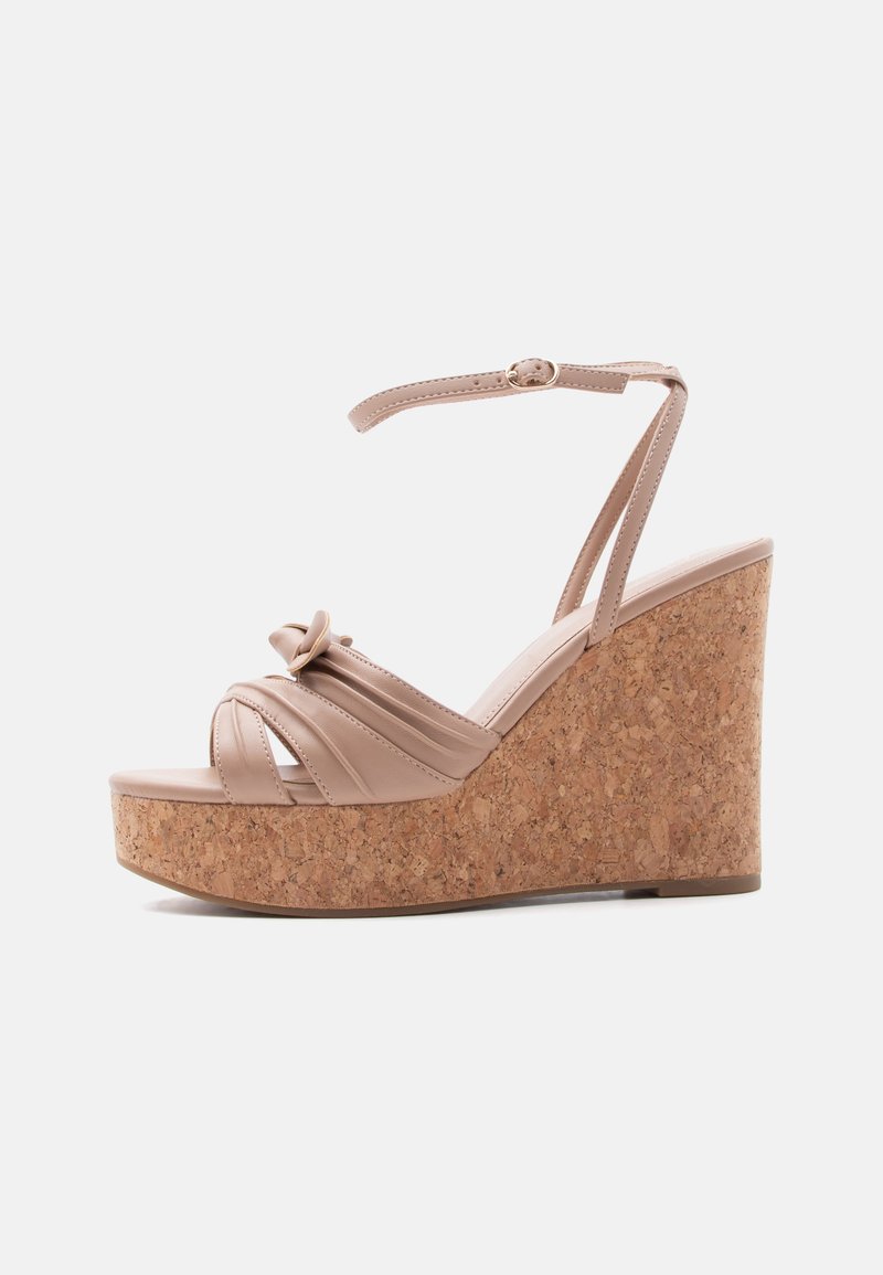 Sandale compensée beige avec semelle plateforme en liège, bride de cheville avec boucle et détail noué sur les brides avant.