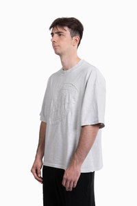 Lys grå kortærmet t-shirt med rund hals, der har et tekstureret cirkulært grafisk motiv på forsiden og en løs, afslappet pasform.