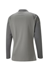 Lange mouwen shirt in lichtgrijs met donkergrijze accenten. Getextureerde schouderpanden hebben een driehoekig patroon. Glad, ademend materiaal.