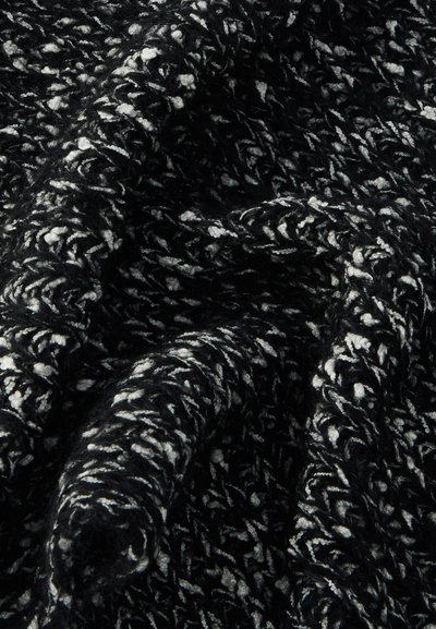 Fekete-fehér texturált kötött anyag csavart, hurkolt mintával, amely puha redőket és árnyékokat alkot.