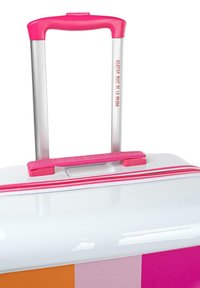 Maleta rígida con un acabado blanco brillante, mango rosa y cremalleras con acentos, y un diseño de rayas en naranja, rosa y amarillo.