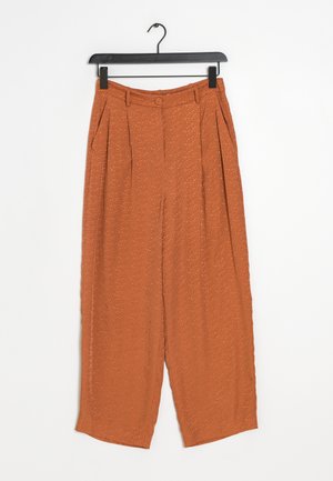 Harmaat housut, jotka on valmistettu kevyestä kankaasta, joissa on teksturoitu pinta, poimut ja yksittäinen nappisulku vyötäröllä.