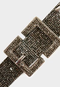 Cintura in pelle nera con fibbia metallica rettangolare a superficie texturizzata, decorata con piccoli chiodini lucidi.