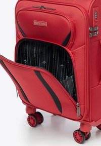 Roter Hartschalenkoffer mit schwarzen Akzenten, Reißverschlußaußenfach, vier Rollen, strukturierte Oberfläche und einem gestreiften Innenmuster.