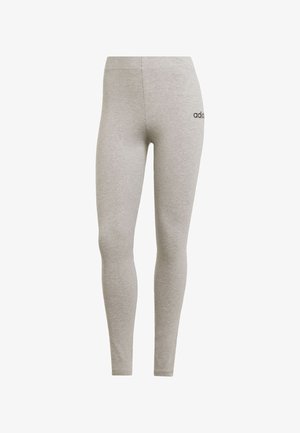 Leggings grises hechos de tejido suave y elástico. Presentan un diseño ajustado con una cinturilla elástica y un pequeño logo negro en la cadera izquierda.