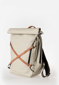 Rolltop-Rucksack in hellbeige, mit ledernen Riemen in Kreuzmuster, schwarzen Reißverschlüssen und verstellbaren gepolsterten Schultergurten.