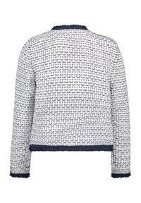 Tweedjacke in Weiß und Marineblau mit einem strukturierten Muster. Merkmale sind ein ausgefranster Saum und Ärmelabschlüsse, lange Ärmel und ein runder Halsausschnitt.