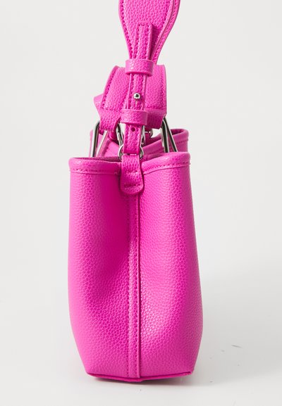 Bright pink textured leather handbag shown from the side with adjustable strap and silver metal hardware against white background.