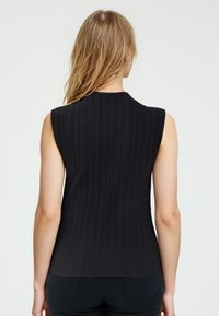 Zwarte mouwloze top met verticale plooien, ronde halslijn en een gladde textuur. Aansluitend ontwerp dat naar de taille toe versmalt, subtiele onderzoom.