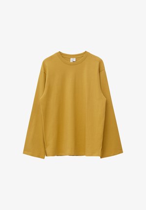 Mosterdgele longsleeve met een ronde hals, rechte zoom en zijsplitten, weergegeven op een witte achtergrond.