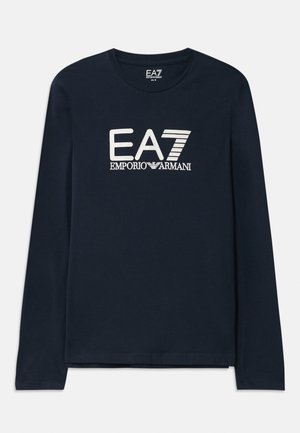 Marineblå langermet t-skjorte i bomull med rund hals. Har EA7 Emporio Armani-logo i hvitt på forsiden. Rett falm med ingen dekorasjoner.