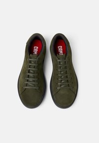 Green suede sneakers with round toe, flat black rubber sole, contrasting red insoles, and six pairs of flat laces. Top view.