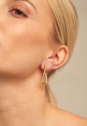 Pendientes colgantes de metal dorado con forma de lágrima y textura lisa y pulida. El diseño presenta un lazo abierto y cuelga con elegancia del lóbulo de la oreja.