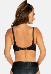 Czarny stanik z błyszczącym nadrukiem w panterkę, regulowanymi ramiączkami i zapięciem na hak. Gładka tekstura i bezszwowy design z tyłu.