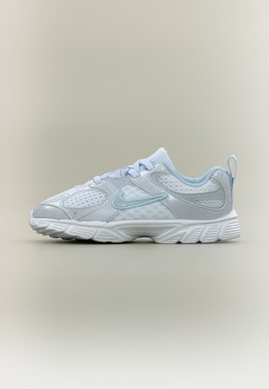 Chaussure de sport Nike blanche et bleu clair avec empiècements en mesh et synthétiques, semelle épaisse et rembourrée, lacets sur fond neutre.