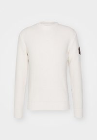 Valkoinen ribbineulottu paita pitkällä hihalla, pyöreällä kaula-aukolla ja pienellä merkintätaskulla vasemmassa hihassa. Pintakuvioitu kangas, jossa ribbineulotut resorit hihansuissa ja helmassa.