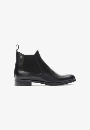 Black leather Chelsea boot with elastic side panels, rounded toe, and a low block heel. Features a pull tab for easy wear.
