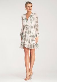 Sukienka w kwiatowy wzór z długimi rękawami, z określonym krojem, z warstwowym falbanym dołem, w jasnoróżowych i zielonych kolorach. Wykonana z lekkiego materiału.