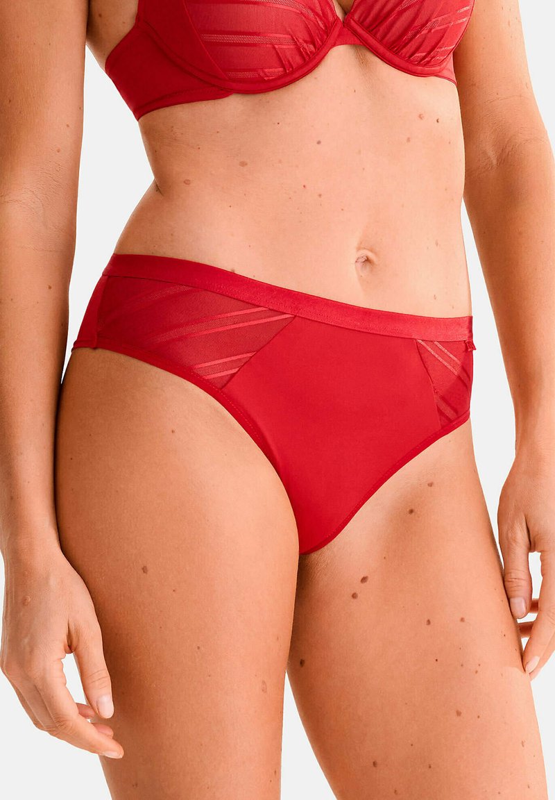 Bas de bikini rouge avec une texture lisse et des panneaux en maille transparente. Dispose d'une taille mi-haute et d'un design simple sans ornements.