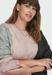 Stickad tröja med en färgblockdesign i rosa, grått och svart. Ribbad ärm och rund halsringning. Mjuk textur, avslappnad passform.